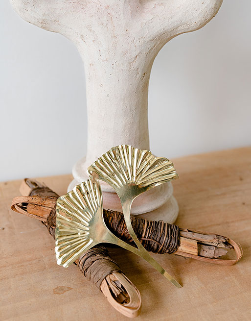 Feuille de ginkgo posé contre un vase sur un plateau en bois