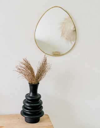 Miroir en forme d'œuf aux bords fins accroché au mur