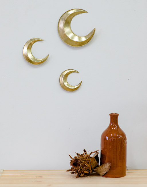Trio de lunes bombées en laiton accrochées sur un mur