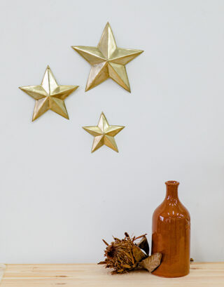 Trio d'étoiles bombées accroché au mur près d'un vase