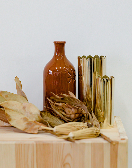 Vases pétales dorés avec feuilles séchées
