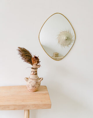 Miroir en forme de losange accroché au mur près d'un vase