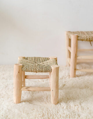 Petit tabouret en paille posé sur un tapis Beni Ouarain blanc