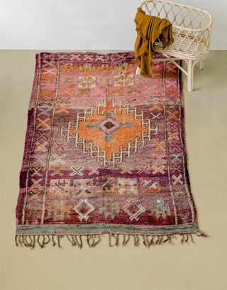 Tapis Boujaad multicolore vu du haut avec un berceau en rotin