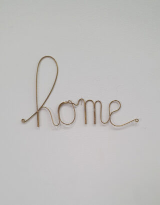 Mot home en laiton accroché au mur