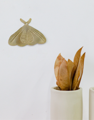 Notre papillon en laiton martelé accroché au mur