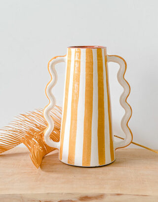 Notre vase rayé jaune posé sur une table