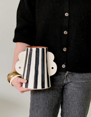 Notre vase avec ses anses et rayures noires dans un décor naturel