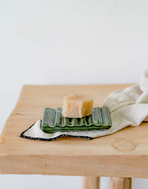 Porte-savon vert de profil posé sur une table