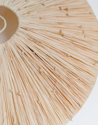 Suspension marocaine courbée en raphia accrochée au mur