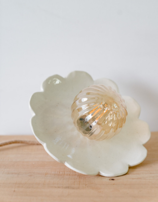 Zoom sur notre suspension en argile posée sur une table en bois