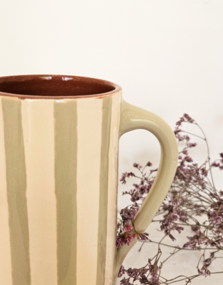 Notre carafe verte rayée posé près de fleurs séchées