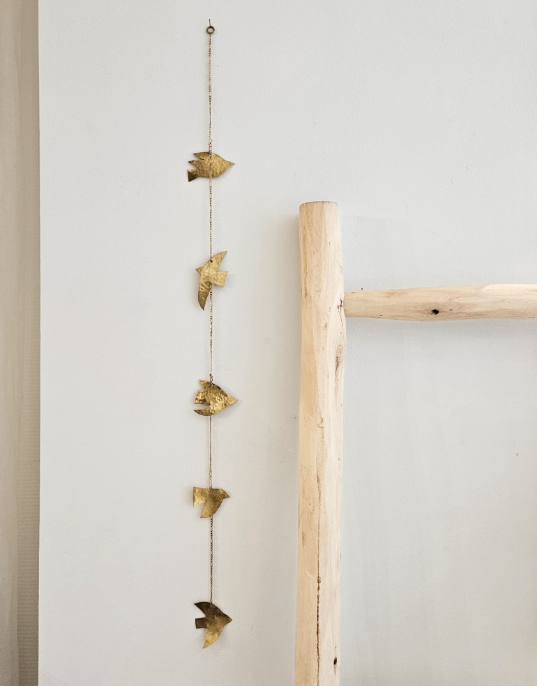 Notre mobile oiseaux suspendu au mur près d'une échelle en bois