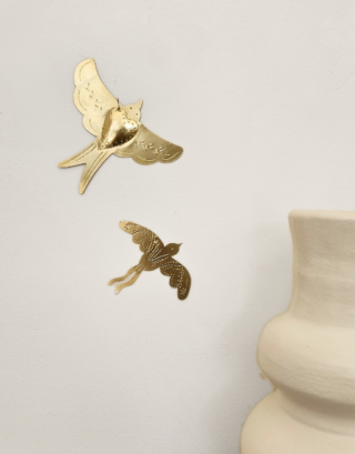 Notre duo d'oiseau murale accrochés au mur près d'un vase blanc