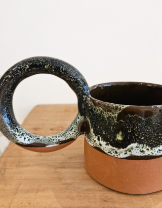 Notre tasse argile posé sur une table près d'une serviette en lin écrue