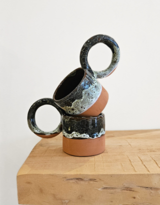 Notre tasse argile posé sur une table près d'une serviette en lin écrue