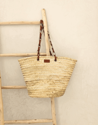 Notre panier Dana avec ses jolies chaînes en laiton et cuir, accroché à une échelle en bois