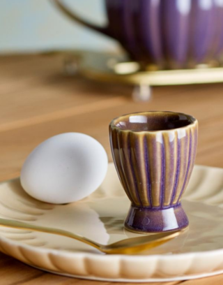 Coquetier violet posé sur la table