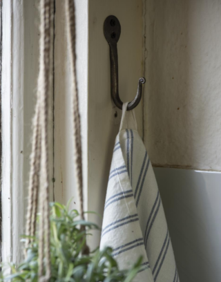 Crochet doré accroché au mur avec un torchon suspendu