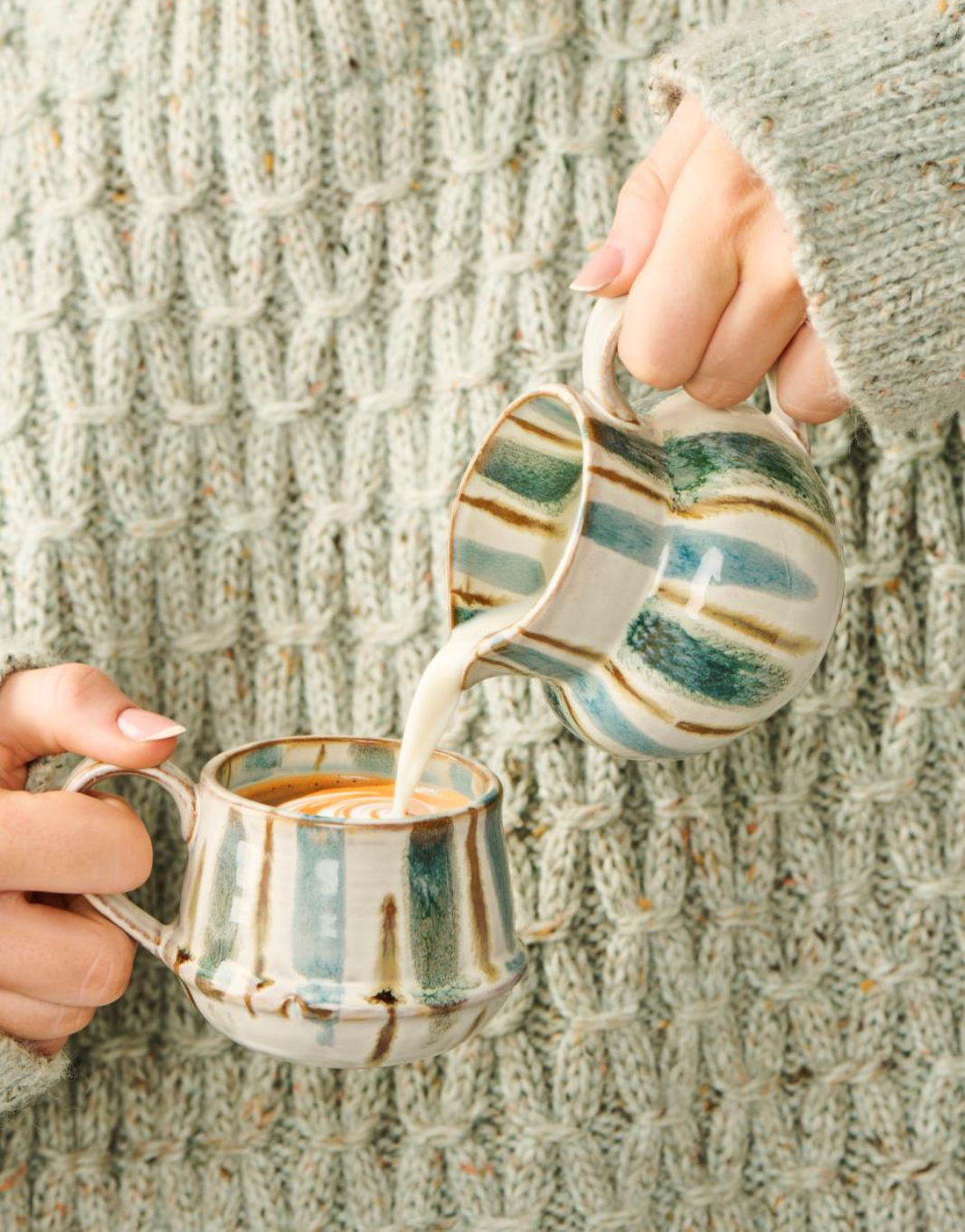 Pichet à lait près d'une tasse tenu par une femme