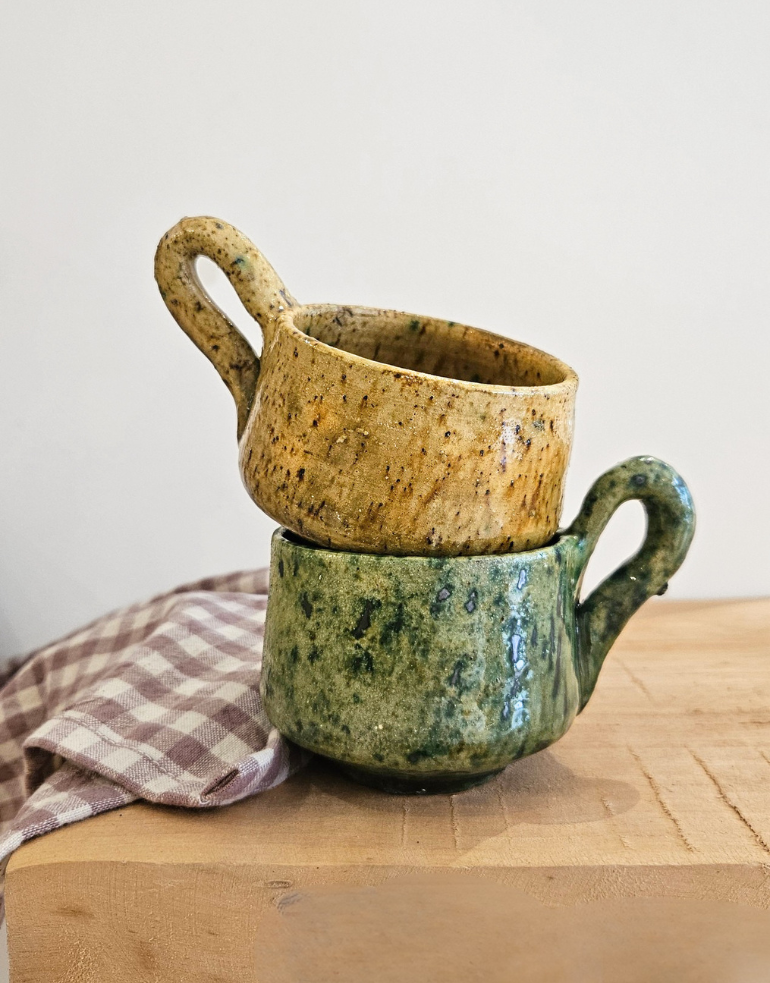 Tasse en Tamegroute posée sur une table en bois près d'un torchon vichy