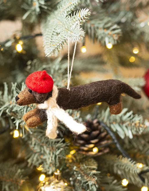 Décoration de chien saucisse accroché à un sapin de Noël.